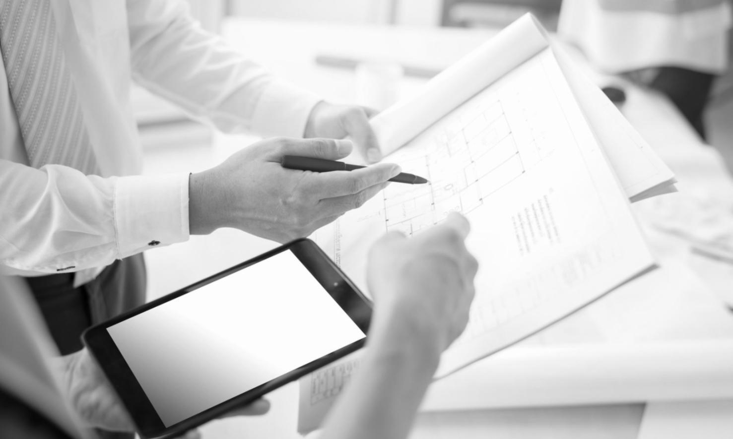 Team members collaborating over financial reports and software interface on desktop screen